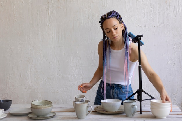 Woman taking photos for her business with ceramic kitchenware