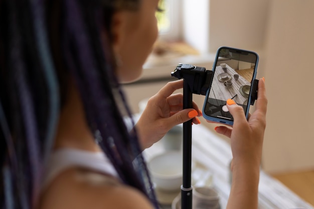 Free photo woman taking photos for her business with ceramic kitchenware