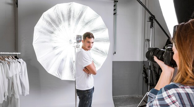 Woman taking photos of model in studio