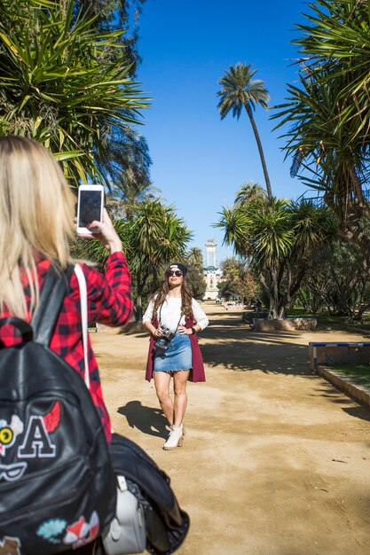 Woman taking picture of friend in park