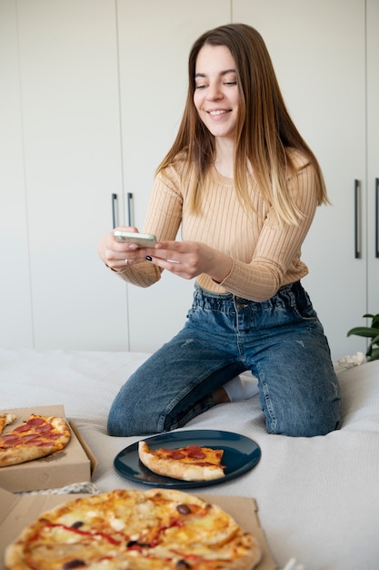 Woman taking picture of pepperoni pizza