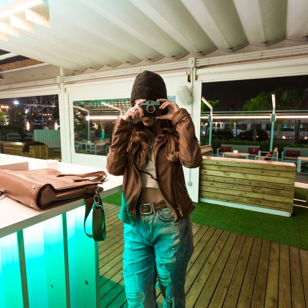 Woman taking pictures near bar