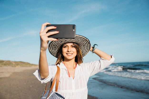 Woman taking selfie at the shoreline