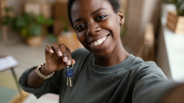 Woman taking selfie while holding the keys of her new home