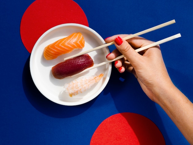 Free photo woman taking with chopsticks a tuna sushi