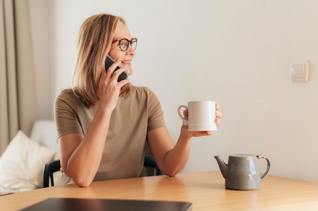 Woman talking on the phone and having coffee during quarantine