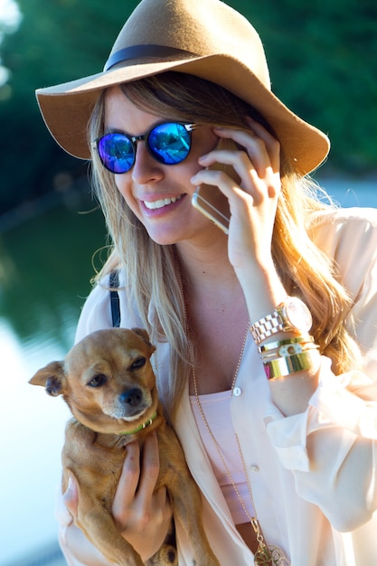 Free photo woman talking phone and holding dog