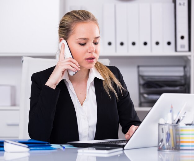 Woman talking on phone in office