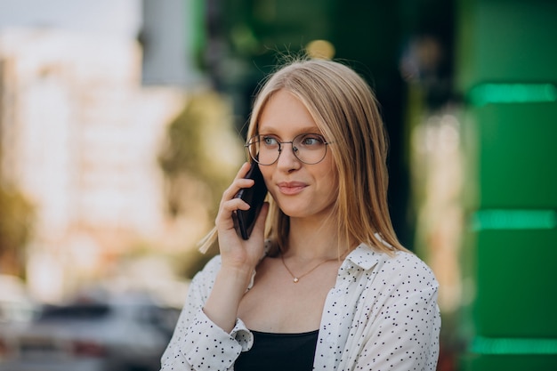 Woman talking on phone outside the street