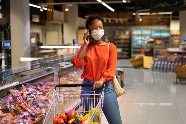 Woman talking on the phone while shopping at the supermarket