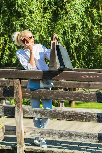 Woman talking smartphone on footbridge 