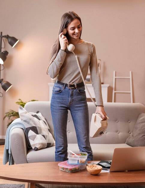 Woman talking on vintage telephone and food