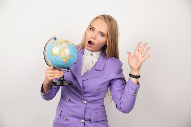 Free Photo woman teacher with globe posing on white.