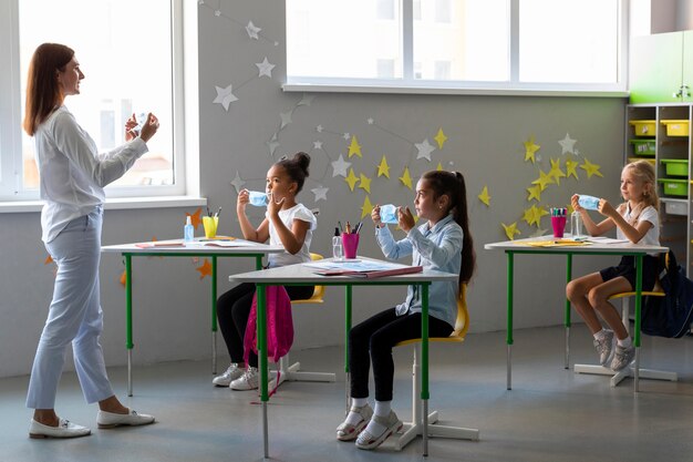 Woman teaching kids how to use a medical mask