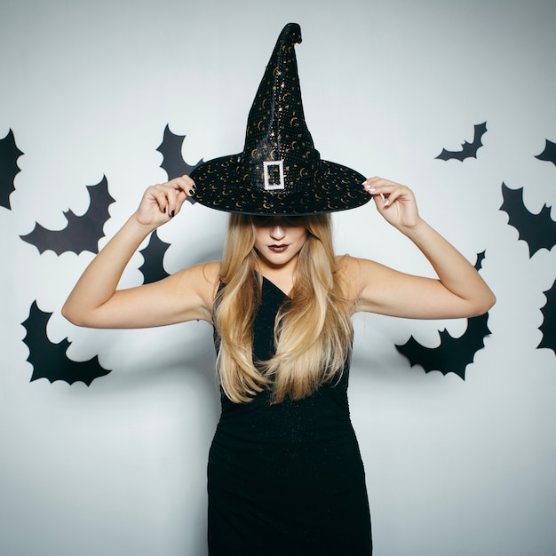 Free Photo woman touching halloween hat