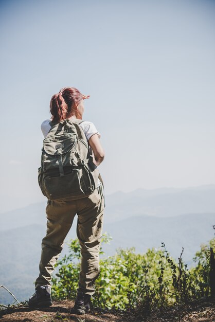 Woman traveler with backpack on beautiful summer landscape.