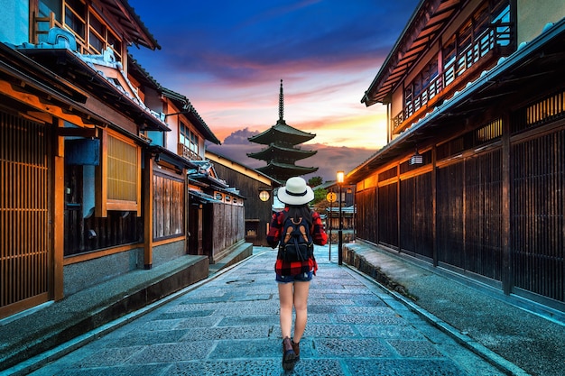 Woman traveler with backpack walking at Yasaka Pagoda and Sannen Zaka Street in Kyoto, Japan.