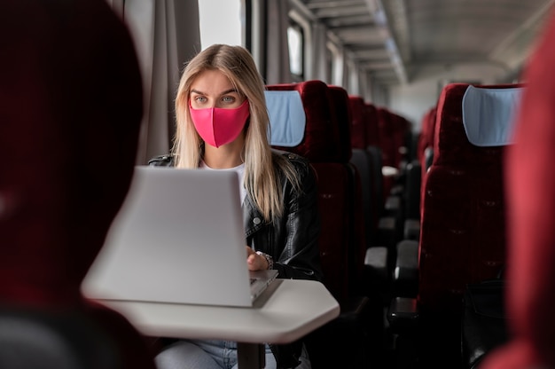 Free photo woman traveling by train and working on laptop