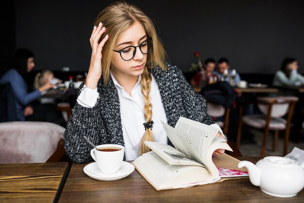 Woman turning book pages in cafe