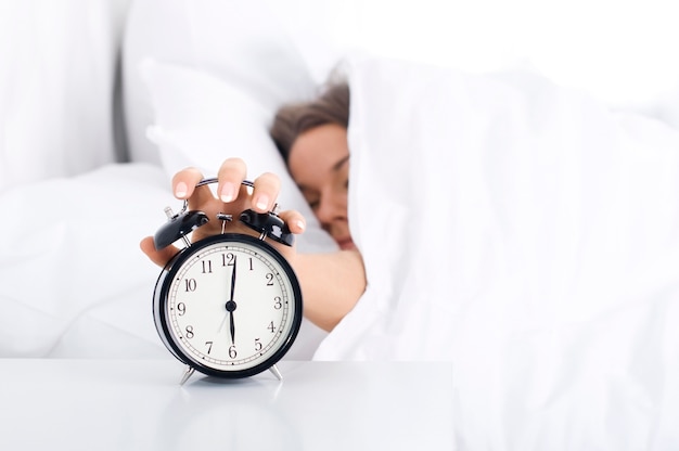 Woman turning off the alarm clock