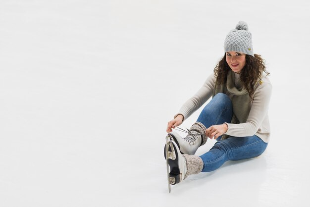 Woman tying laces on ice