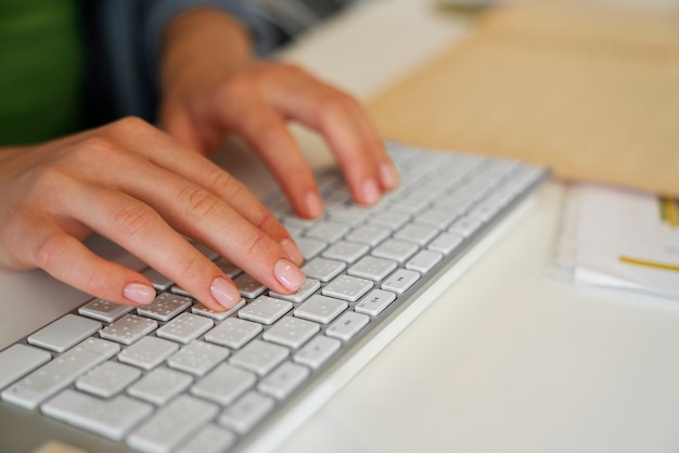 Free Photo woman typing on keyboard at work