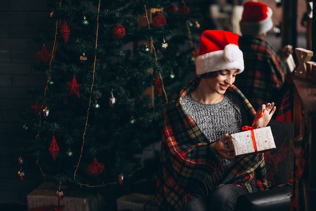 Woman unpacking presents by Christmas tree