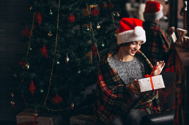 Woman unpacking presents by Christmas tree