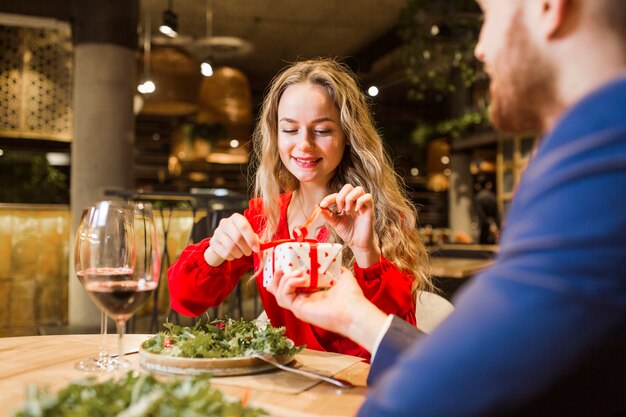 Free photo woman untying bow on present from man