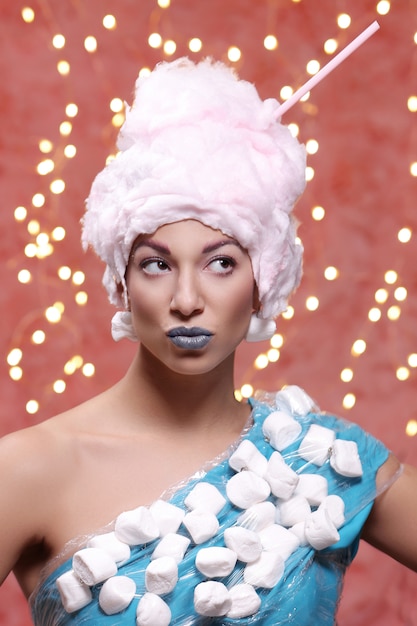 Woman in unusual dress made of marshmallow and wig of cotton candy