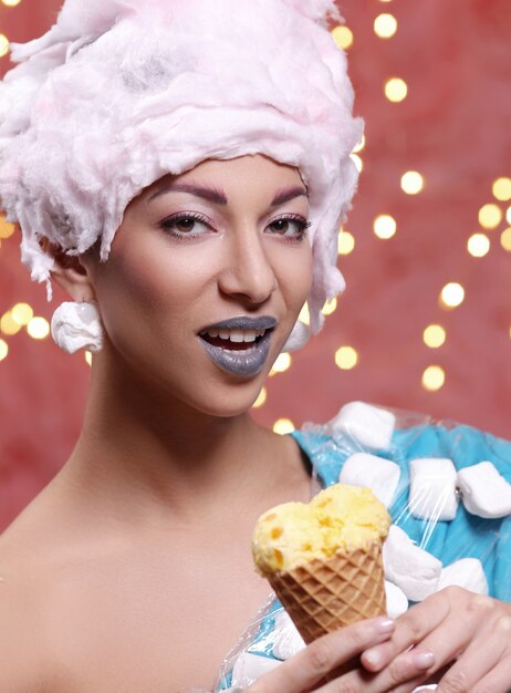 Woman in unusual dress made of marshmallow and wig of cotton candy