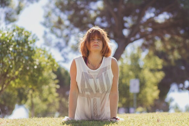 Woman in upward-facing dog pose in park