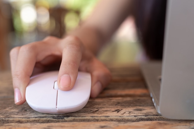 Free Photo woman using computer mouse with laptop.