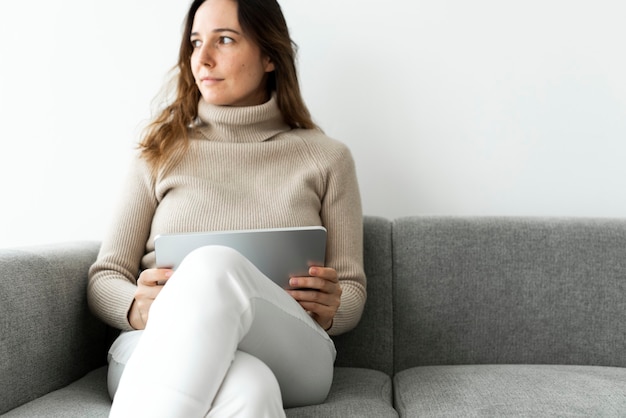 Woman using digital tablet on a couch