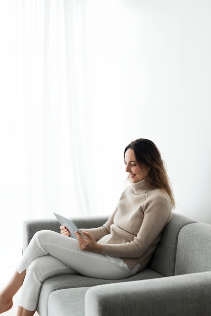 Woman using digital tablet on a couch