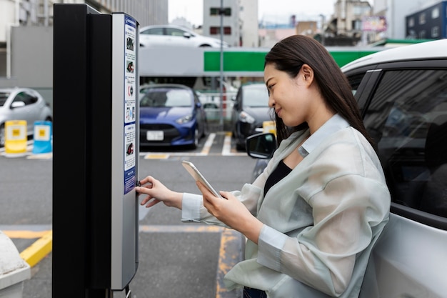 Free photo woman using the electric car charging station