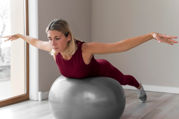 Free photo woman using a fitness ball for her workout