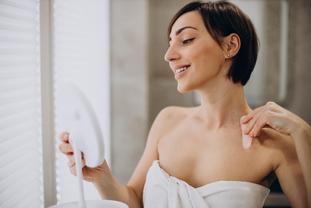 Woman using gua sha stone at spa