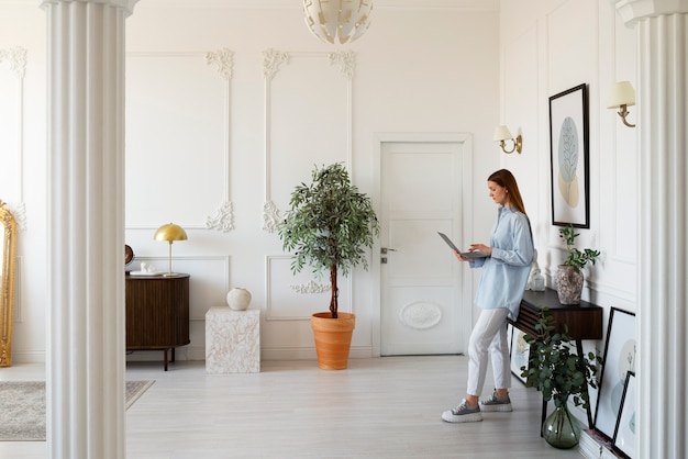 Free Photo woman using laptop in minimal decorated room