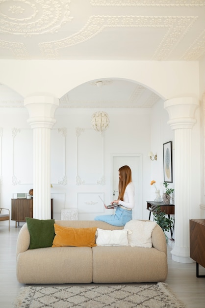 Free photo woman using laptop in minimal decorated room