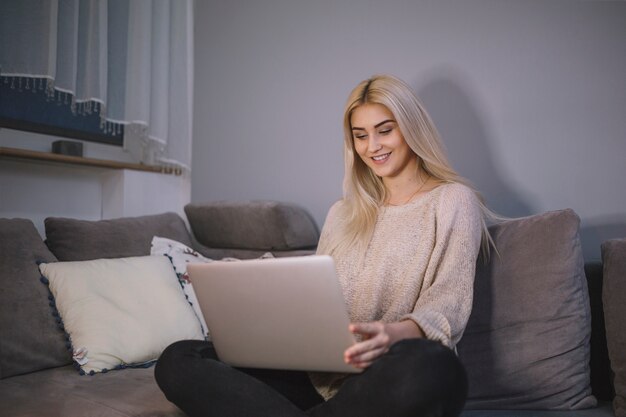 Woman using laptop on sofa