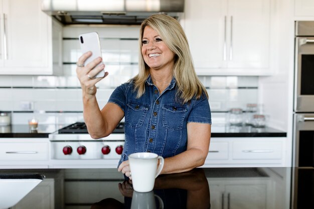 Woman using a mobile phone in the kitchen