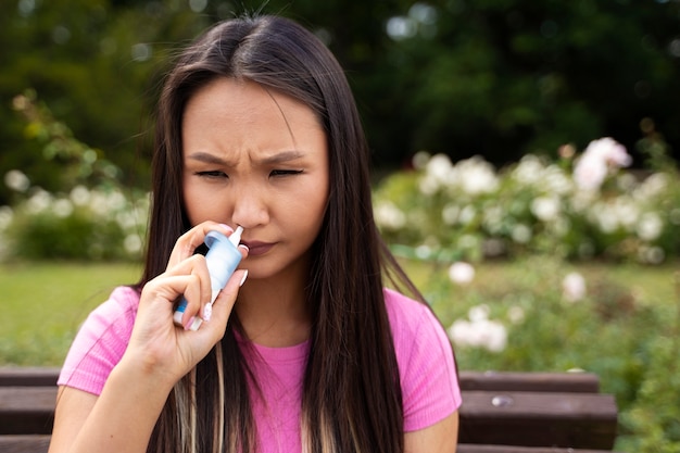 Free photo woman using nasal spray front view