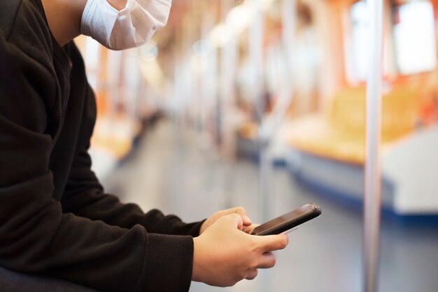 Woman using a phone on an empty train during coronavirus pandemic