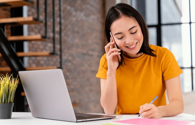 Woman using phone while attending online class