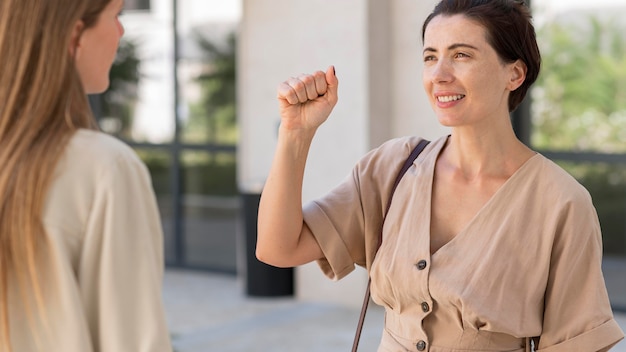 Woman using sign language to converse with her friend