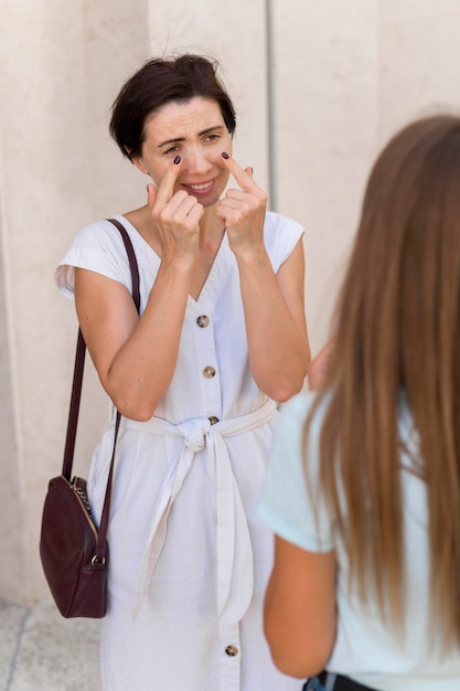 Free photo woman using sign language to convey crying to her friend