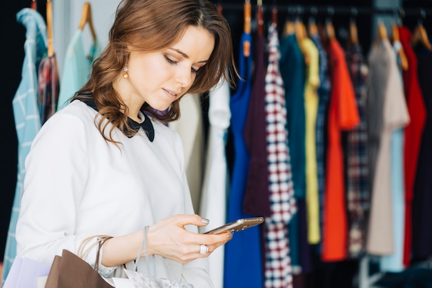 Woman using smarthone in shop