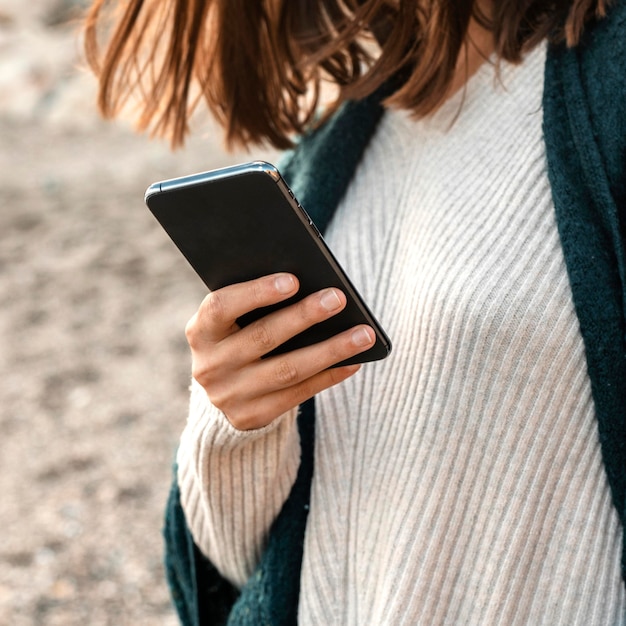 Free Photo woman using smartphone at the beach