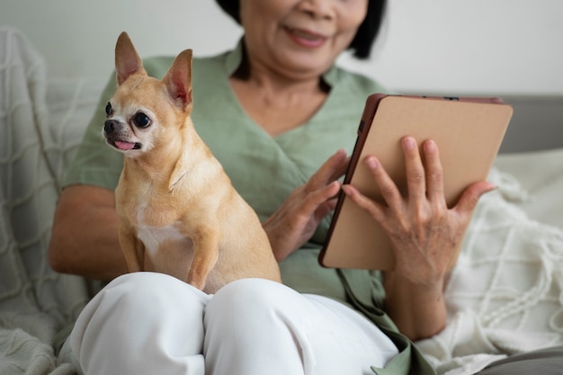 Free photo woman using a tablet at home next to her dog